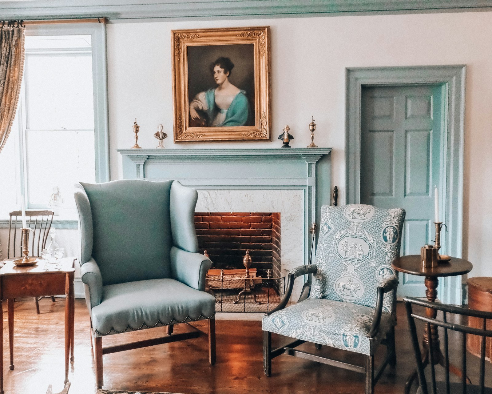 The Coach House sitting room, wing chairs drawn up to an open fire