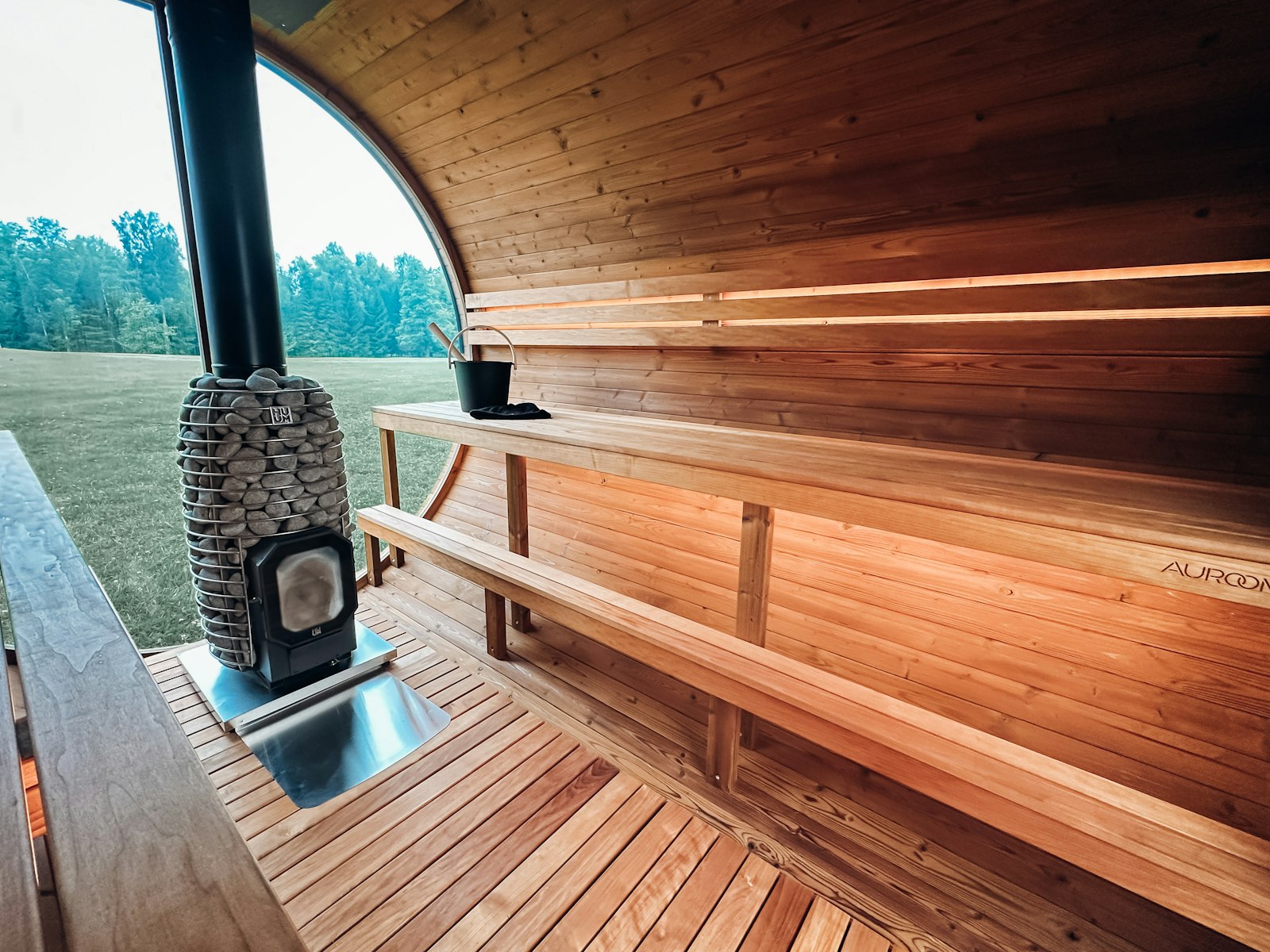 The wood-fired sauna at the treeline, stove lit and the door open